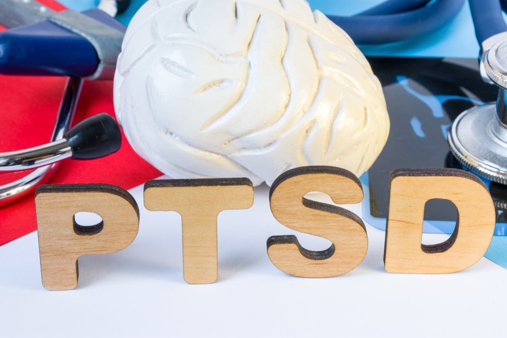 Image of a Brain, various medical devices, and Letters Spelling out PTSD to signify Trauma